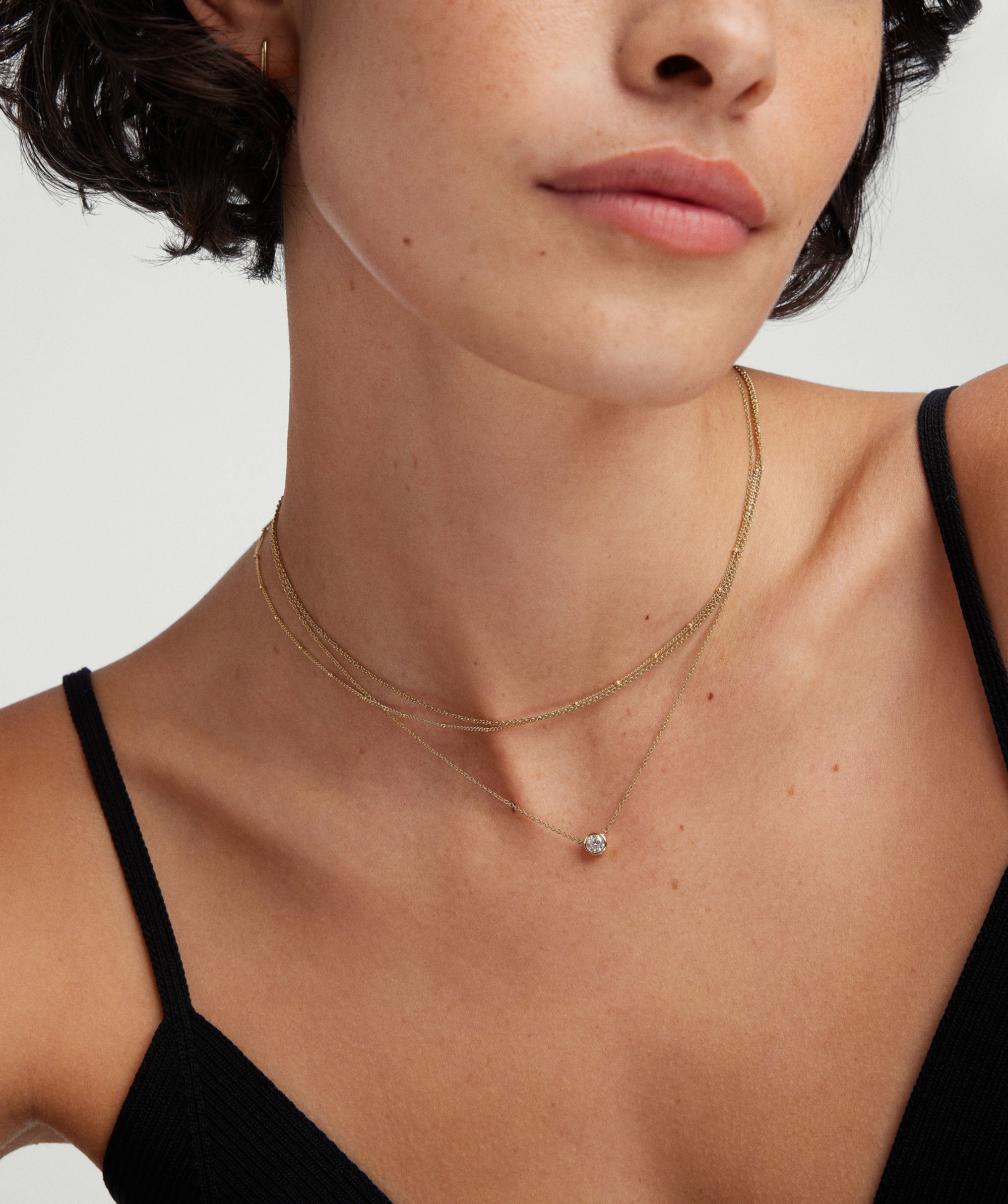Bezel Lab Grown Diamond Necklace worn by a woman, featuring a bezel-set diamond on a 14k solid gold chain.