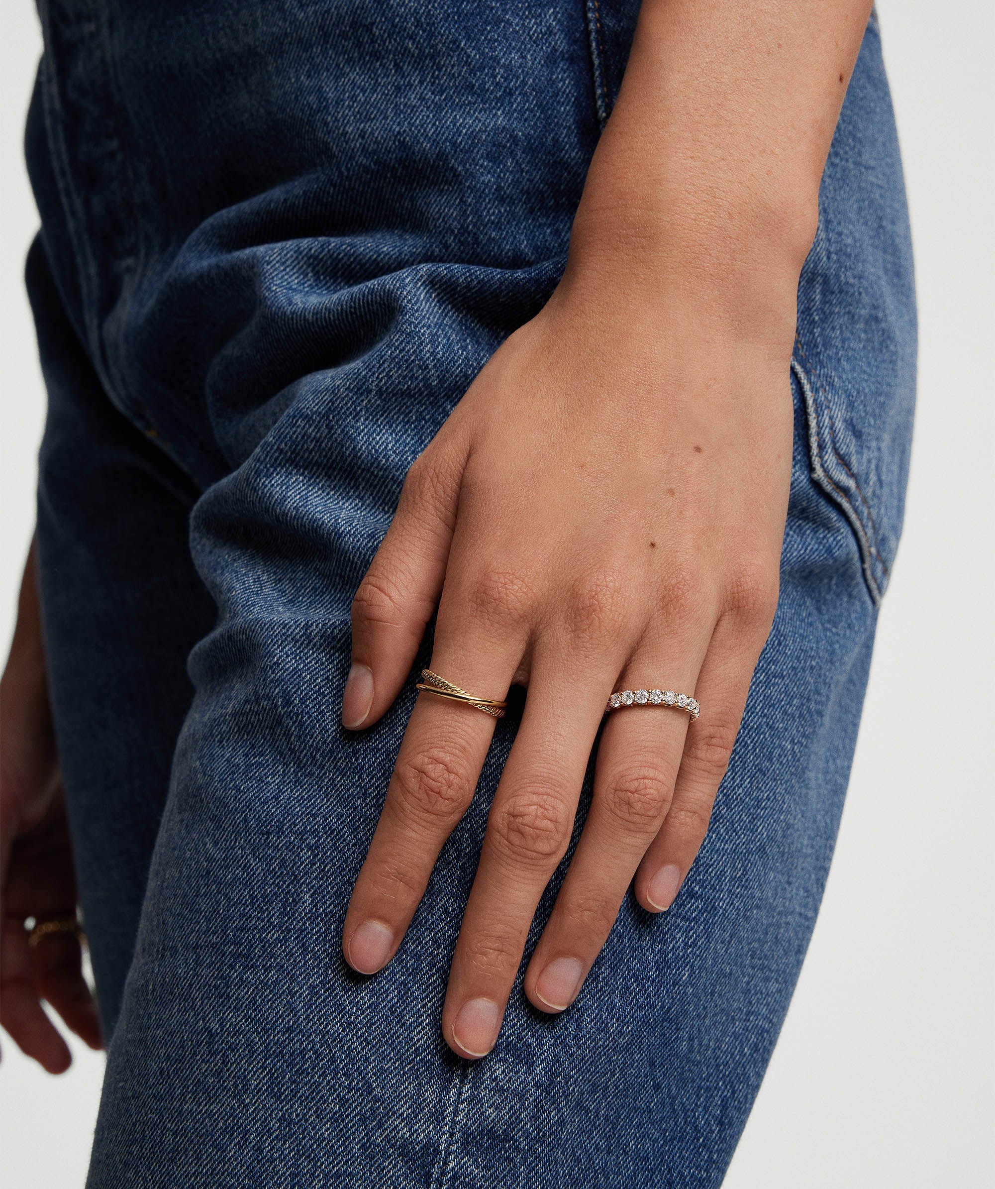 Hand with a 3mm Lab Grown Diamond Eternity Band on a finger, showcasing the sparkling diamonds set in handcrafted 14k solid gold.