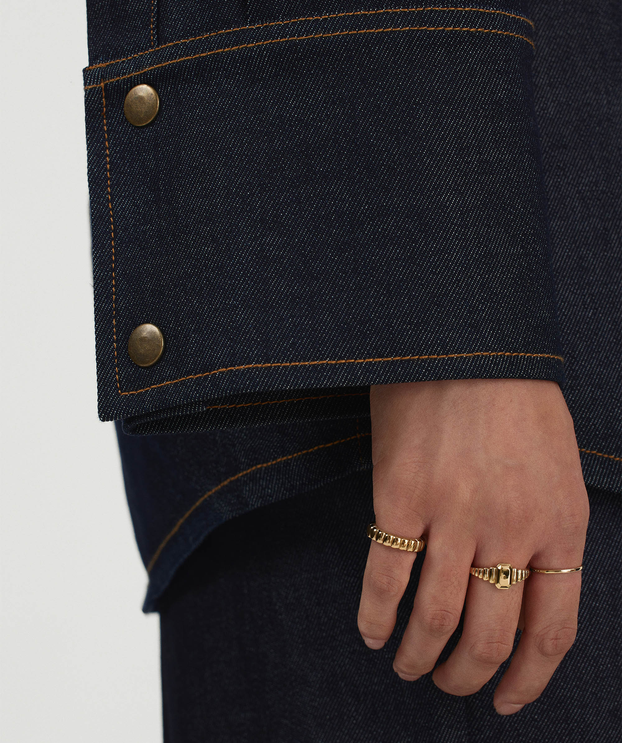 Close-up of a hand wearing the Charlotte Step Cut Signet Ring, showcasing its engravable texture as a standout fashion accessory.