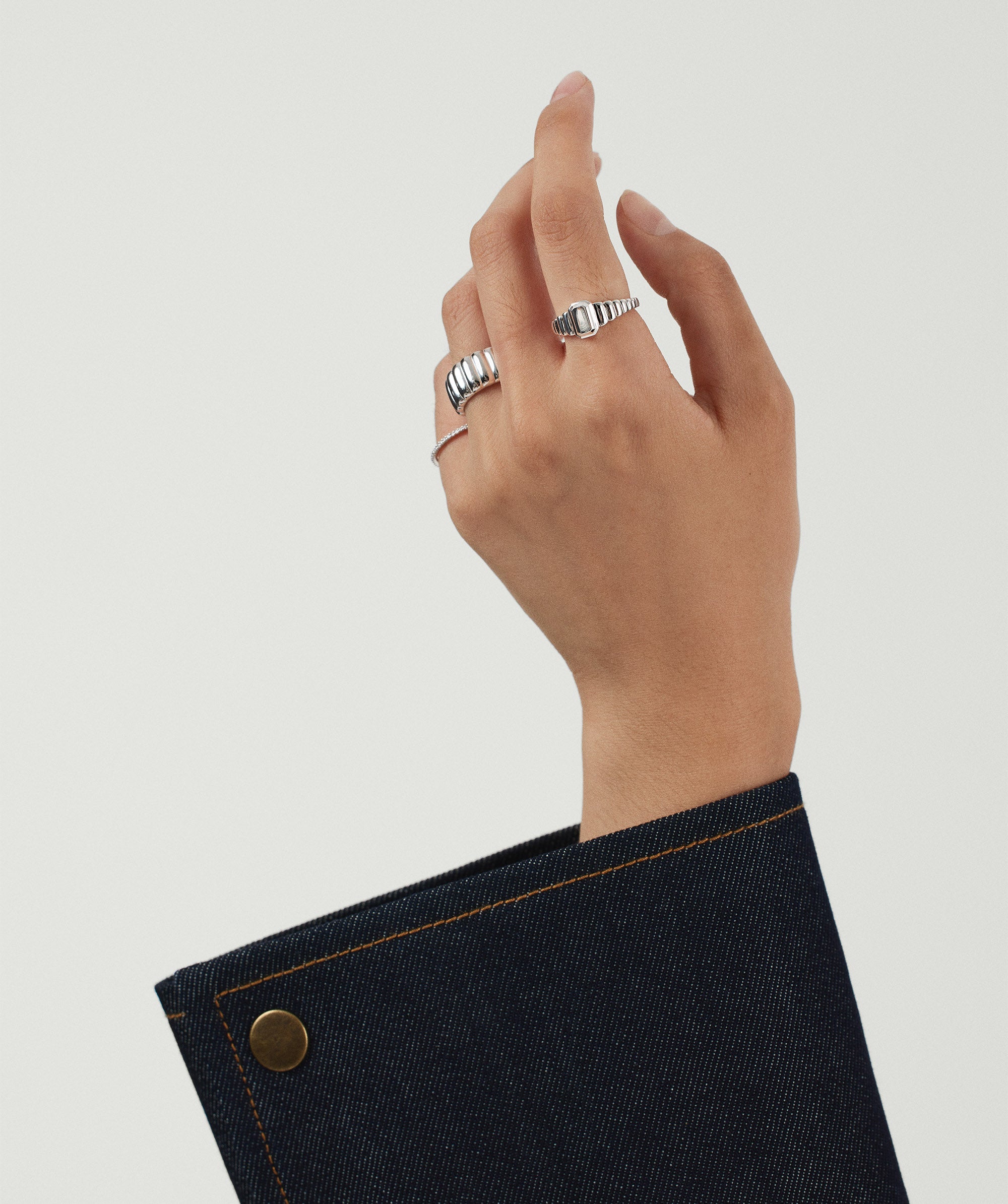 Charlotte Step Cut Signet Ring on a hand, showcasing its engravable surface and textured design, elegantly enhancing the wearer's style as a statement accessory.
