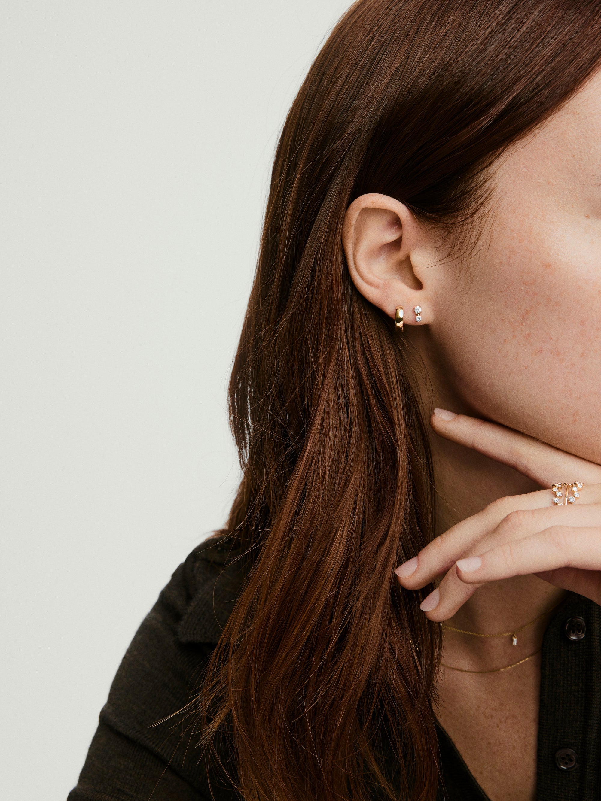 Droplet Lab Grown Diamond Stud: Close-up of a woman's ear adorned with two linked lab-grown diamonds, showcasing elegant movement and refined sparkle.