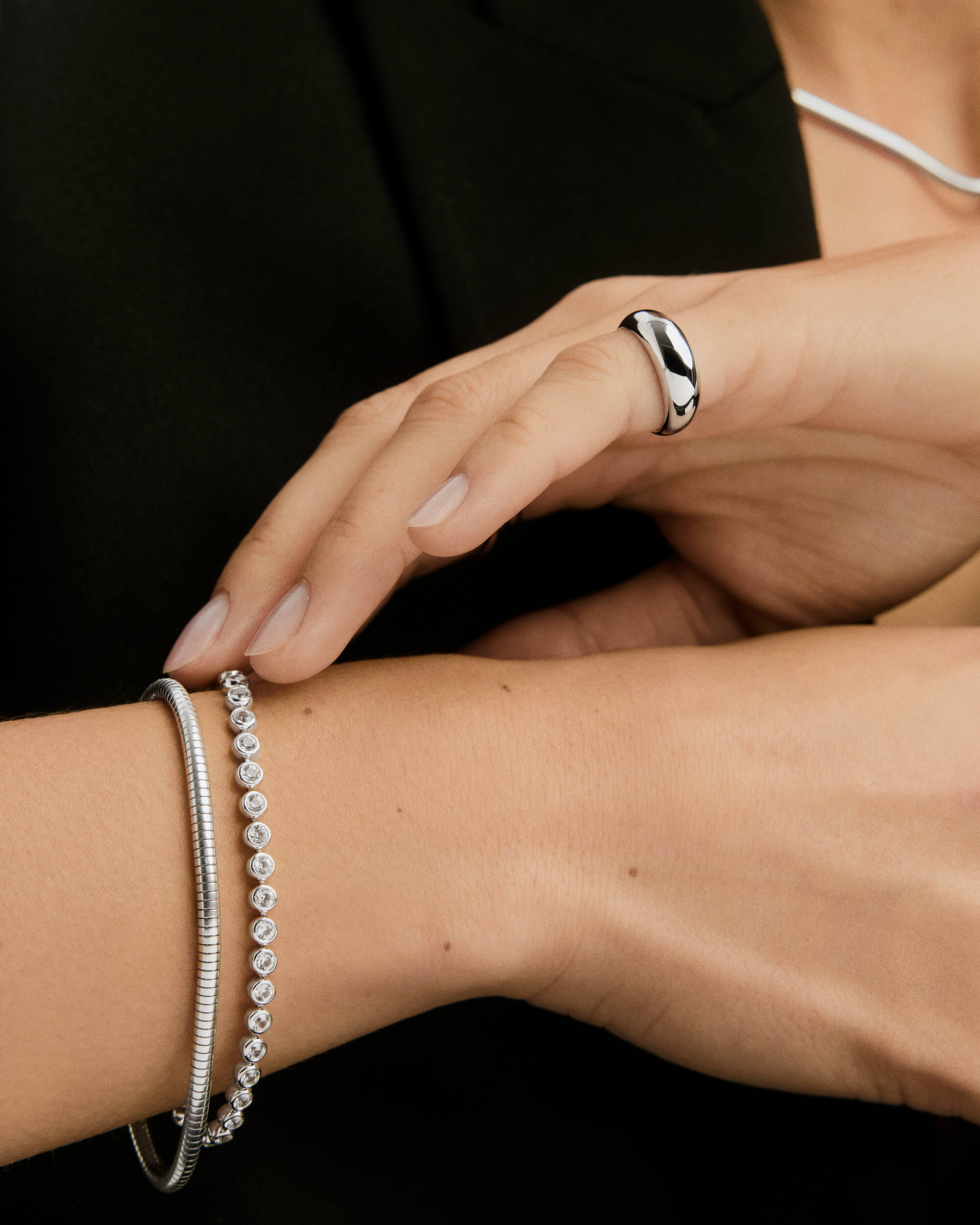 Zadie Bezel Lab Grown Sapphire Tennis Bracelet elegantly adorns a woman's wrist, showcasing its bezel-set sapphires, capturing the essence of sophisticated jewelry design.