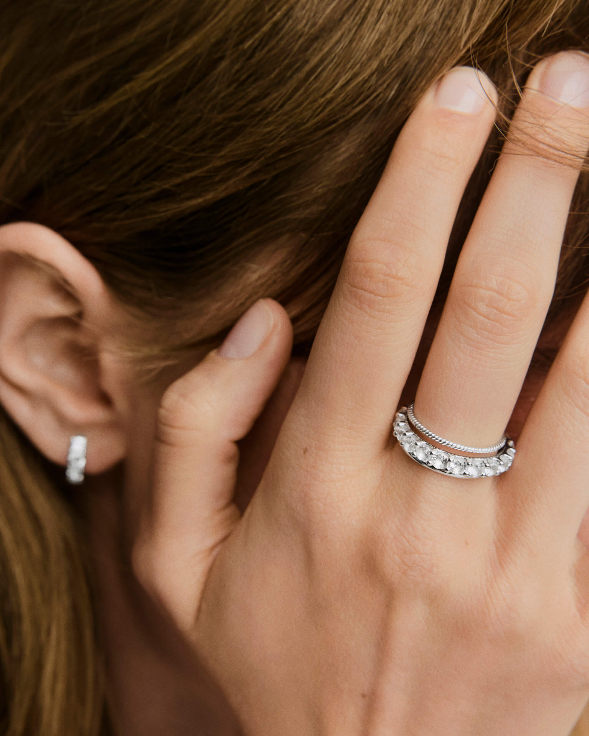 Close-up of a hand wearing the Aurora Lab Grown Sapphire Eternity Ring, showcasing its continuous band of lab-grown sapphires for a striking look.
