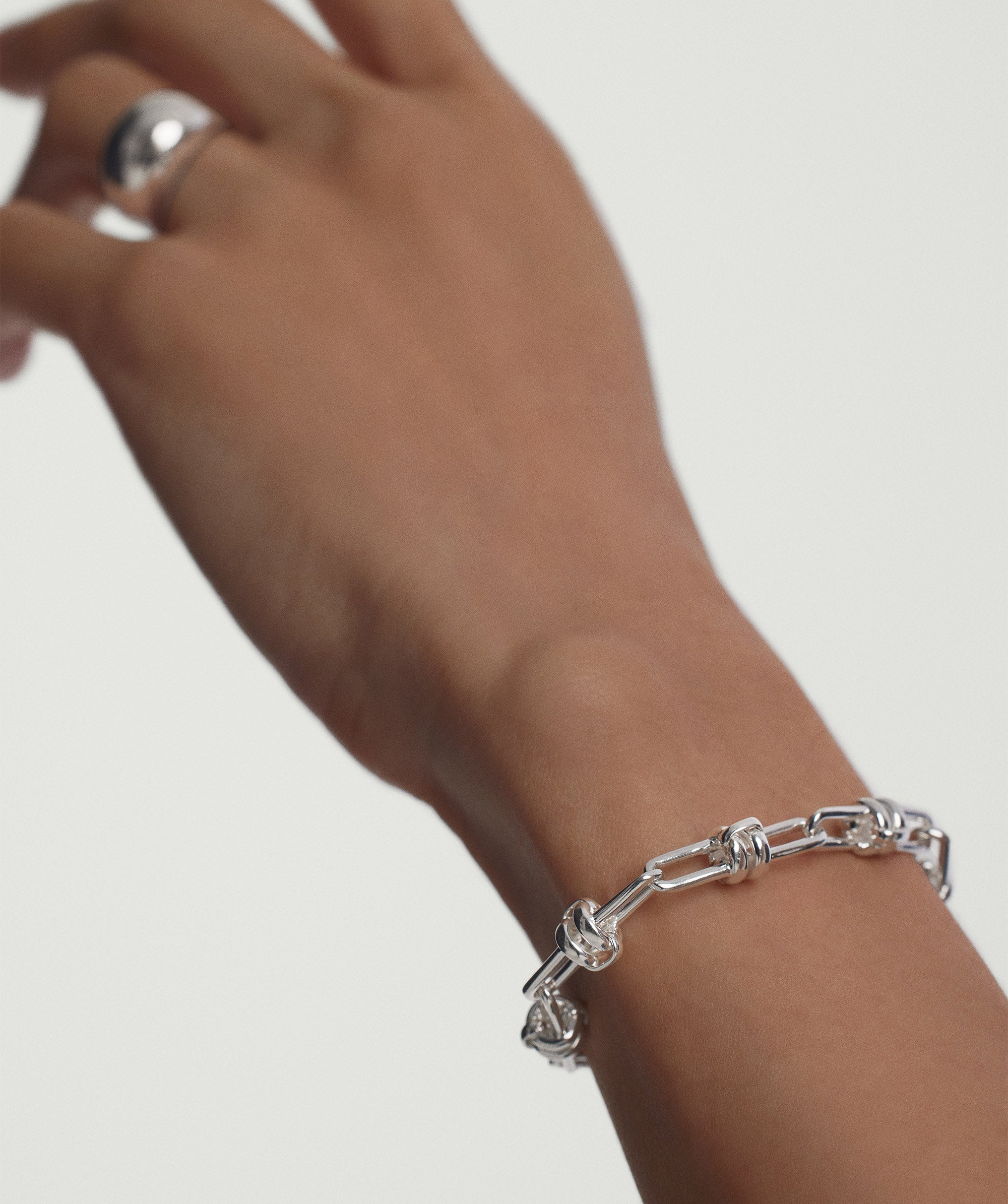 Hand wearing the Mejuri Custom Chain Bracelet, a unique, customizable silver piece designed for adding charms and personal touches.
