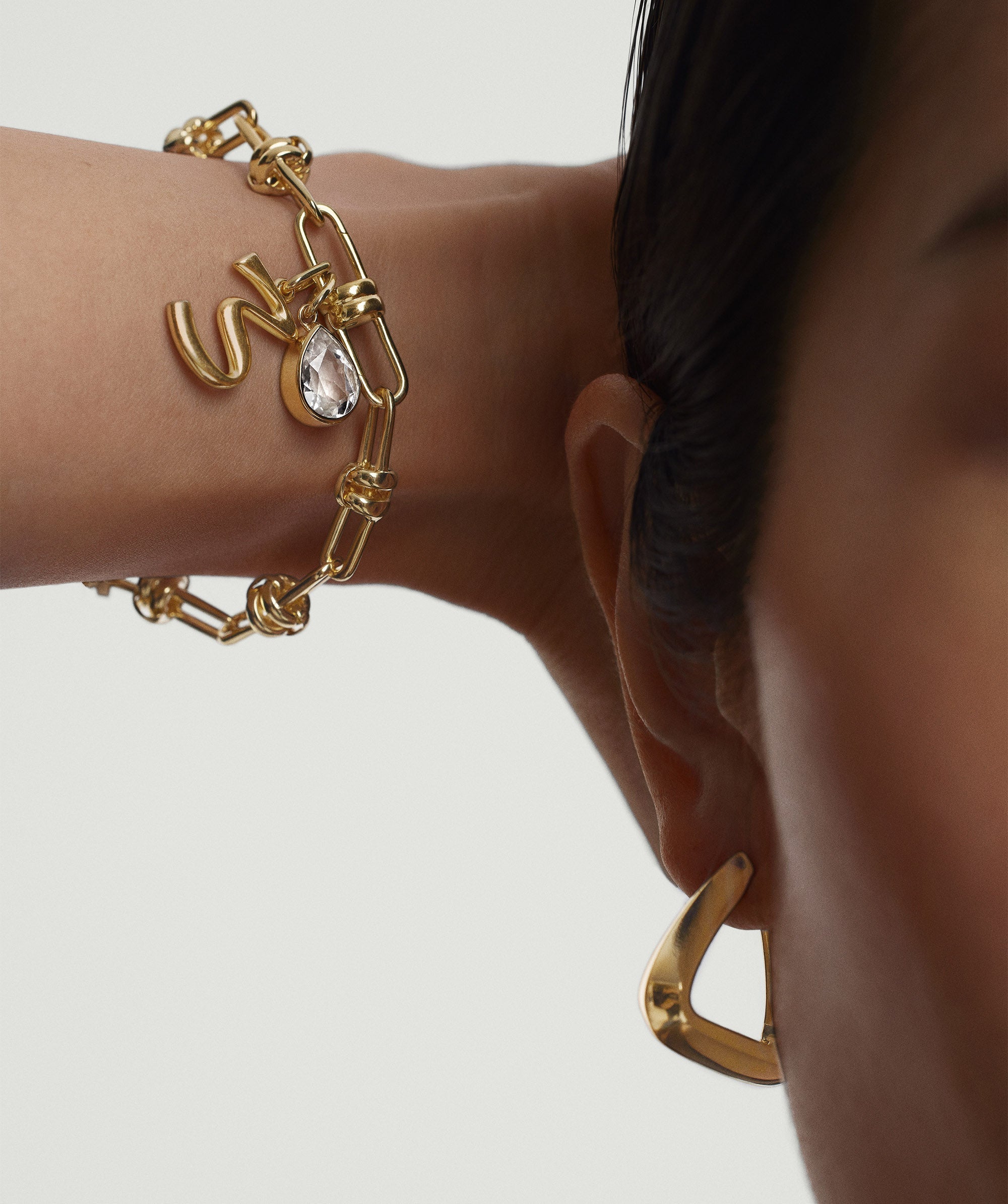 Close-up of a woman's arm wearing the Mejuri Custom Chain Bracelet, showcasing its unique, adjustable design and charm customization options.