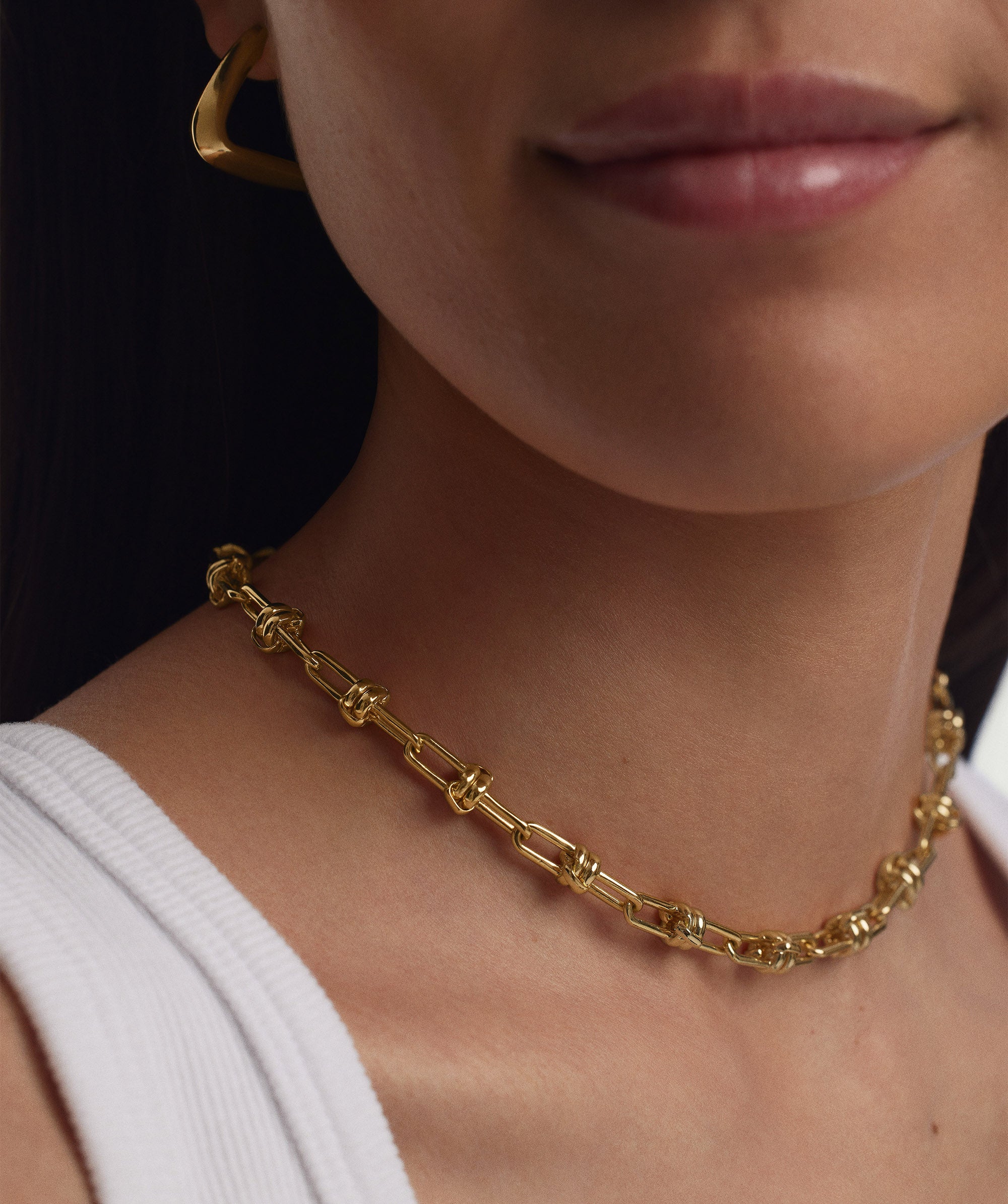 Woman wearing a Multi Way Chain Necklace around her neck, showcasing its versatile gold links designed for customizable lengths and charm additions.