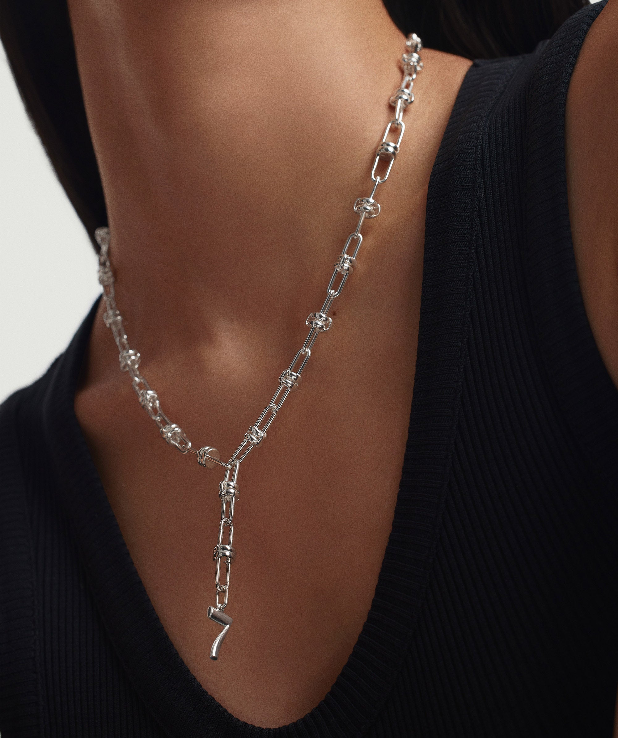 A woman wearing the Multi Way Chain Necklace, a versatile jewelry piece designed for customization, allowing various lengths and charm combinations.
