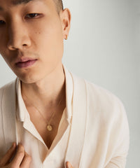 Man wearing a white sweater showcases the Cable Chain Necklace in 14k solid yellow gold, highlighting its timeless and simple design.
