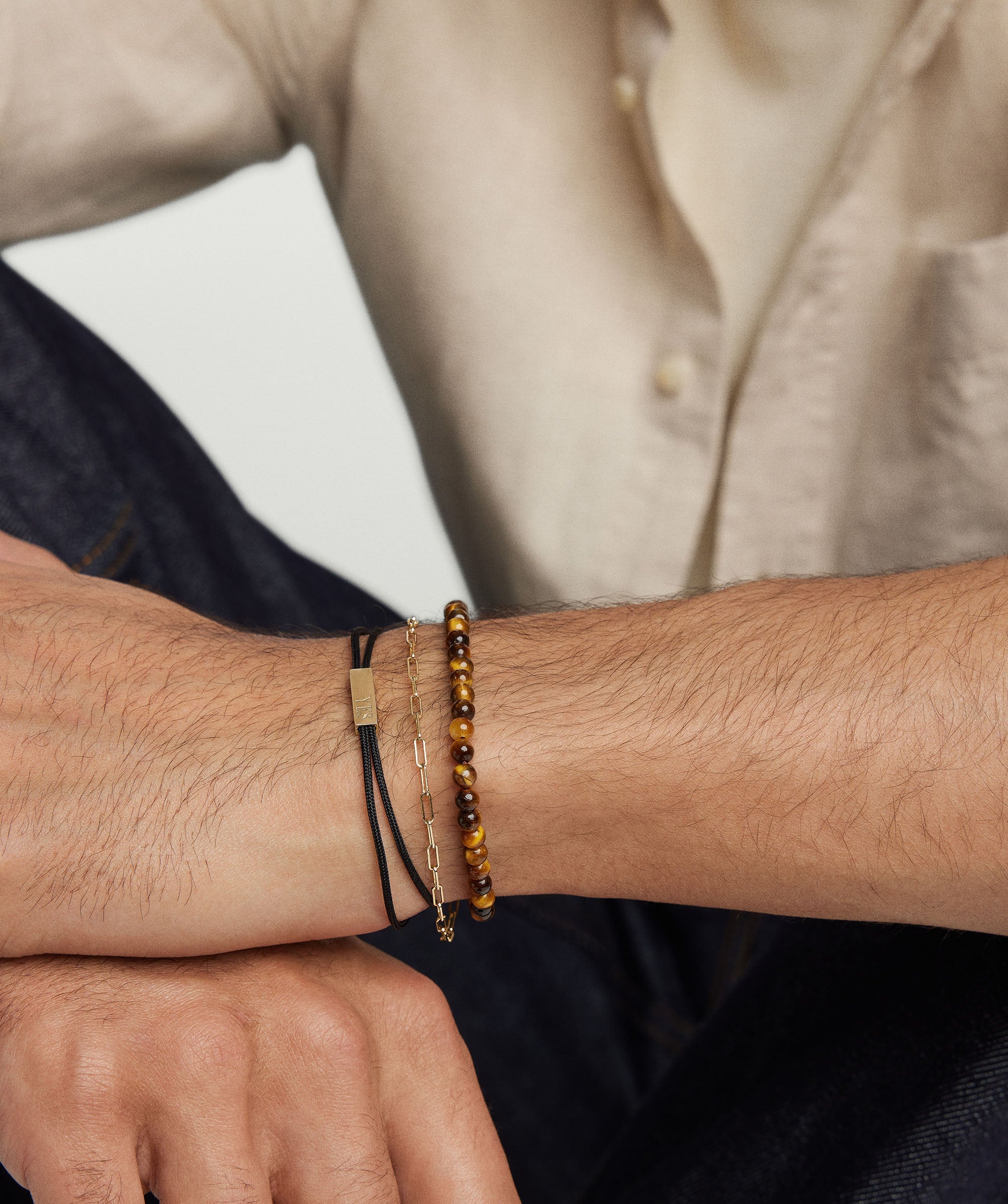 Close-up of a man's wrist showcasing the Bar Cord Bracelet, a beaded fashion accessory, highlighting its intricate design and craftsmanship.