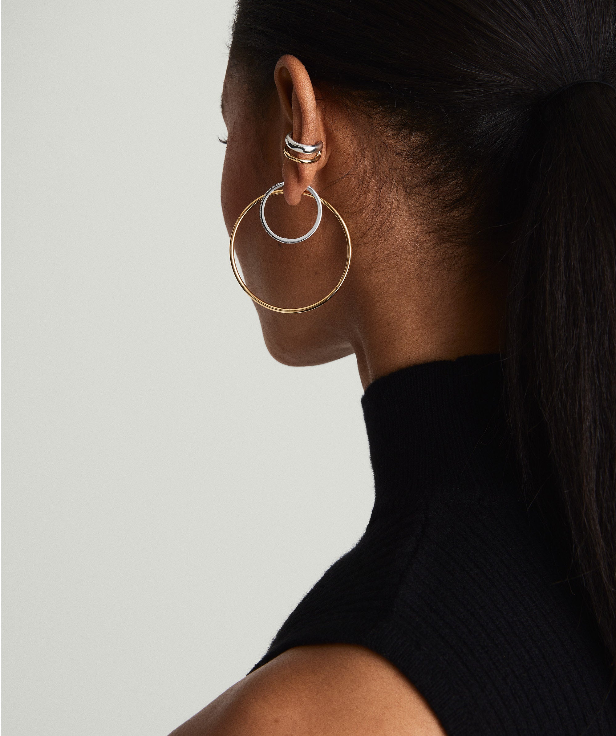 Woman wearing the Duet Mixed Ear Cuff, featuring mixed metals in two widths, handcrafted in 18k gold vermeil and sterling silver.
