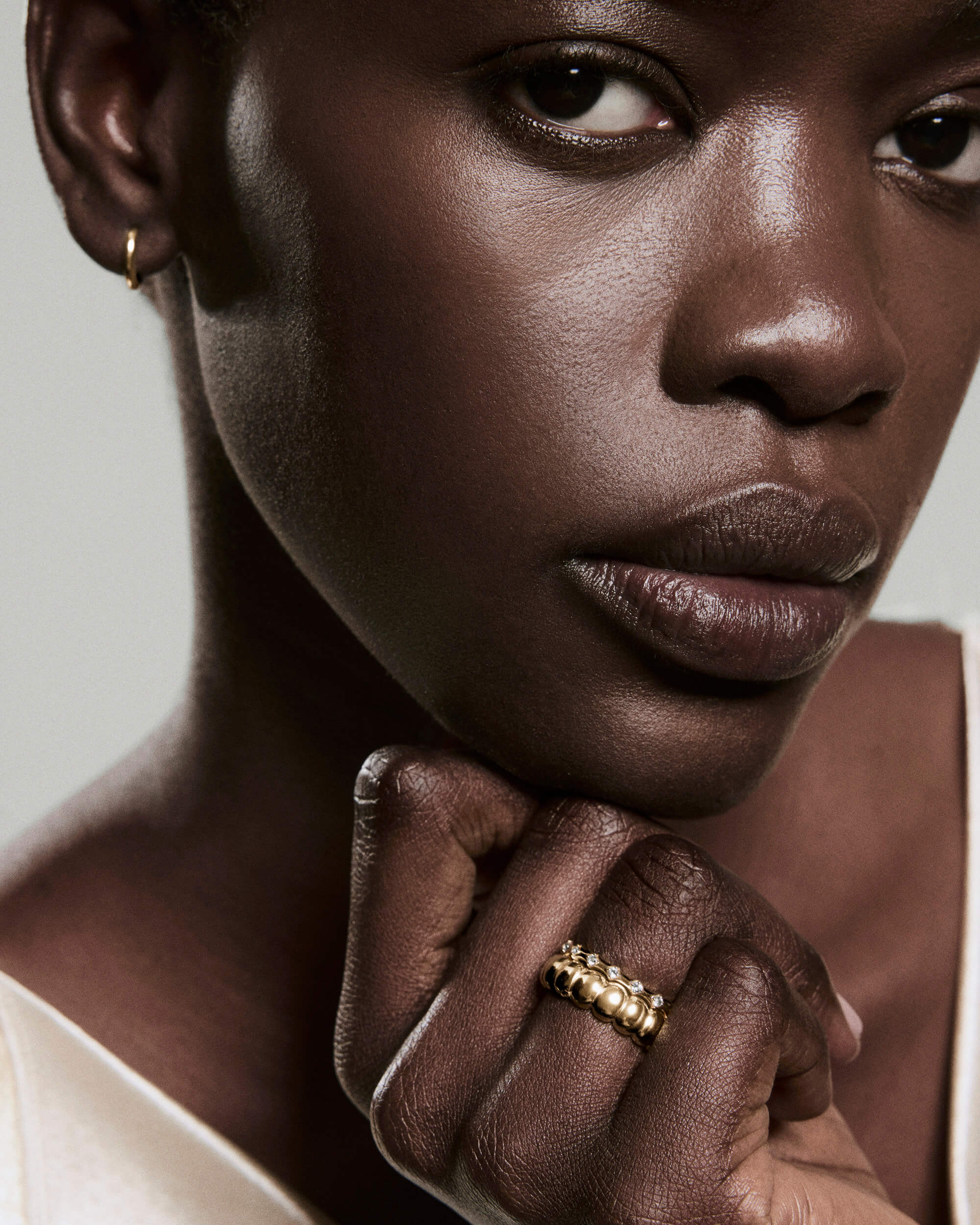 Close-up of a person showcasing the Classic Charlotte Stacker Bundle, featuring the Puffy and Crest Charlotte gold rings, highlighting their rounded, bead-like design.