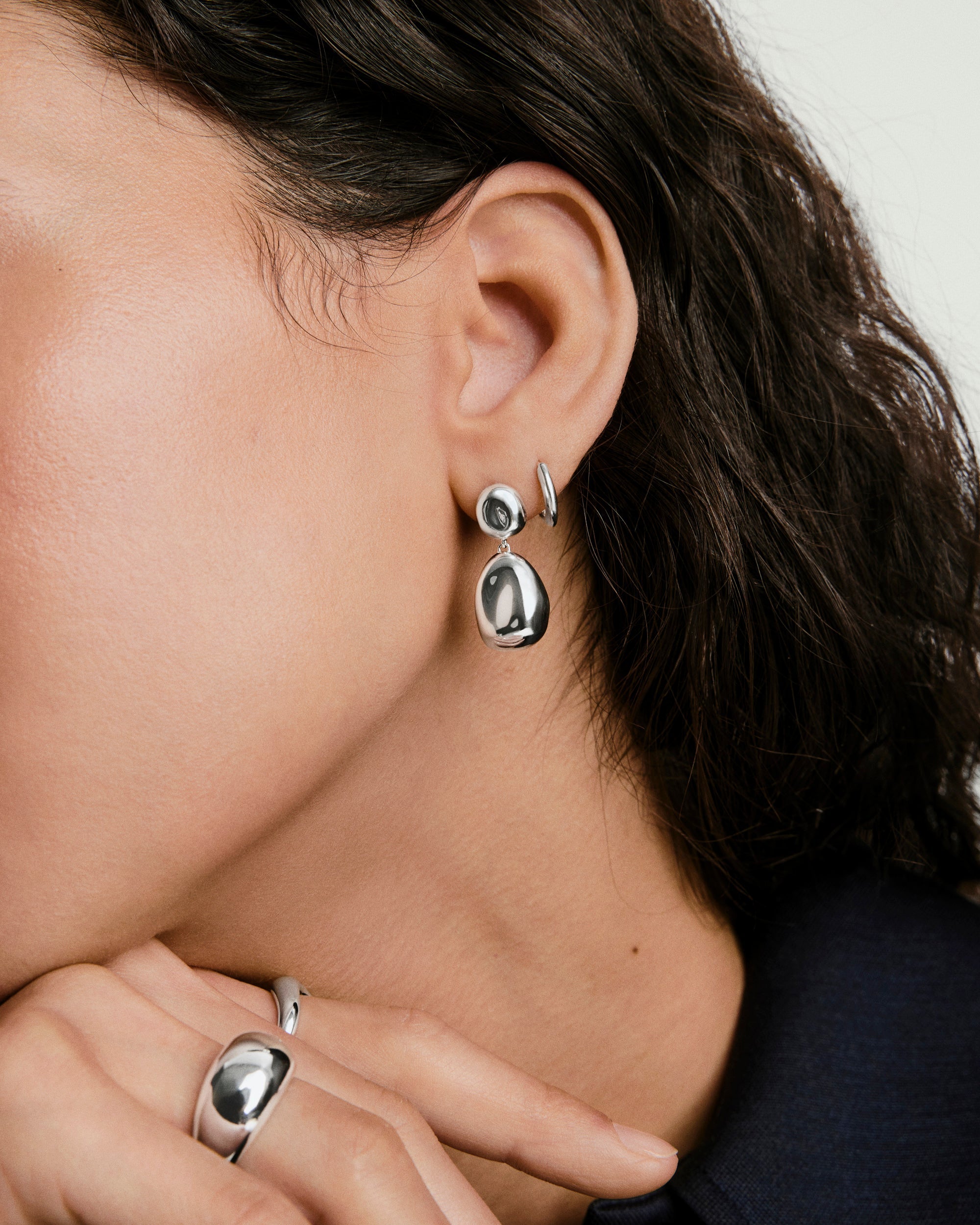 Close-up of a woman wearing Organic DÃ´me Pebble Earrings, showcasing their natural drop design and elegant, versatile style from the DÃ´me collection.