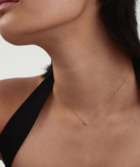 Close-up of a woman wearing the PavÃ© Diamond Evil Eye Necklace, featuring intricate detailing symbolizing protection against envy and evil.