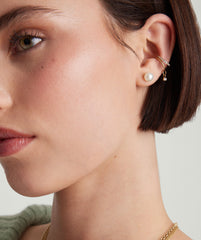 Close-up of a woman's face wearing Pearl Oversized Studs in 18k gold vermeil with freshwater pearls.