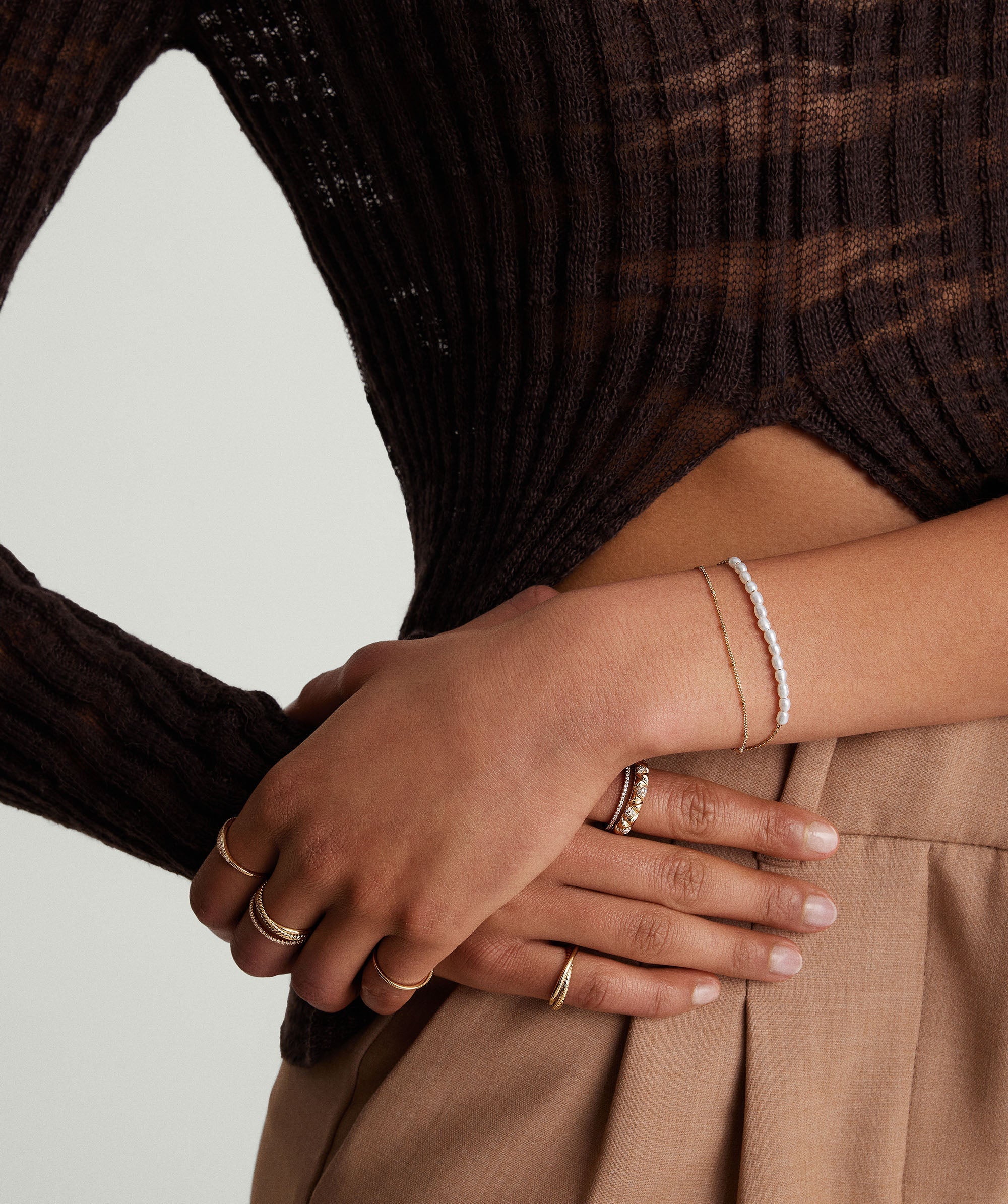 Close-up of a woman's hands showcasing a delicate Tiny Pearl Bracelet, highlighting its elegant design and subtle charm.