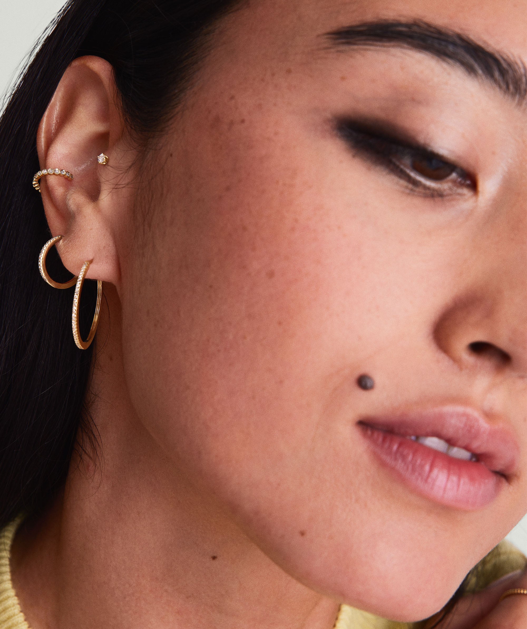 Diamond Ear Cuff: Close-up of a woman's ear adorned with a 14k gold ear cuff featuring responsibly sourced diamonds, showcasing its elegant, no-piercing-required design.