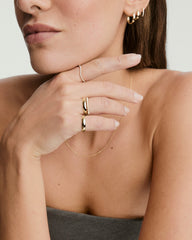 Close-up of a woman's hand wearing the Pearl Half Eternity Ring, showcasing its stack of pearls set in recycled 14k solid gold.