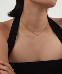Woman wearing a Layered Bar Necklace, featuring multiple delicate layers elegantly draped around her neck as a versatile, everyday fashion accessory.