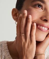 Close-up of a woman smiling, showcasing the PavÃ© Diamond Star Open Ring on her finger, featuring 14k gold and pavÃ© diamonds.