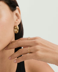 Close-up of a woman's hand wearing a braided ring, showcasing its chain-style design, symbolizing unity and strength.