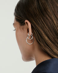 Woman wearing the Tube Hoops Bundle, showcasing Huggie, Medium, and Large Tube Hoops. Fine jewelry, perfect for stacking and enhancing any look.