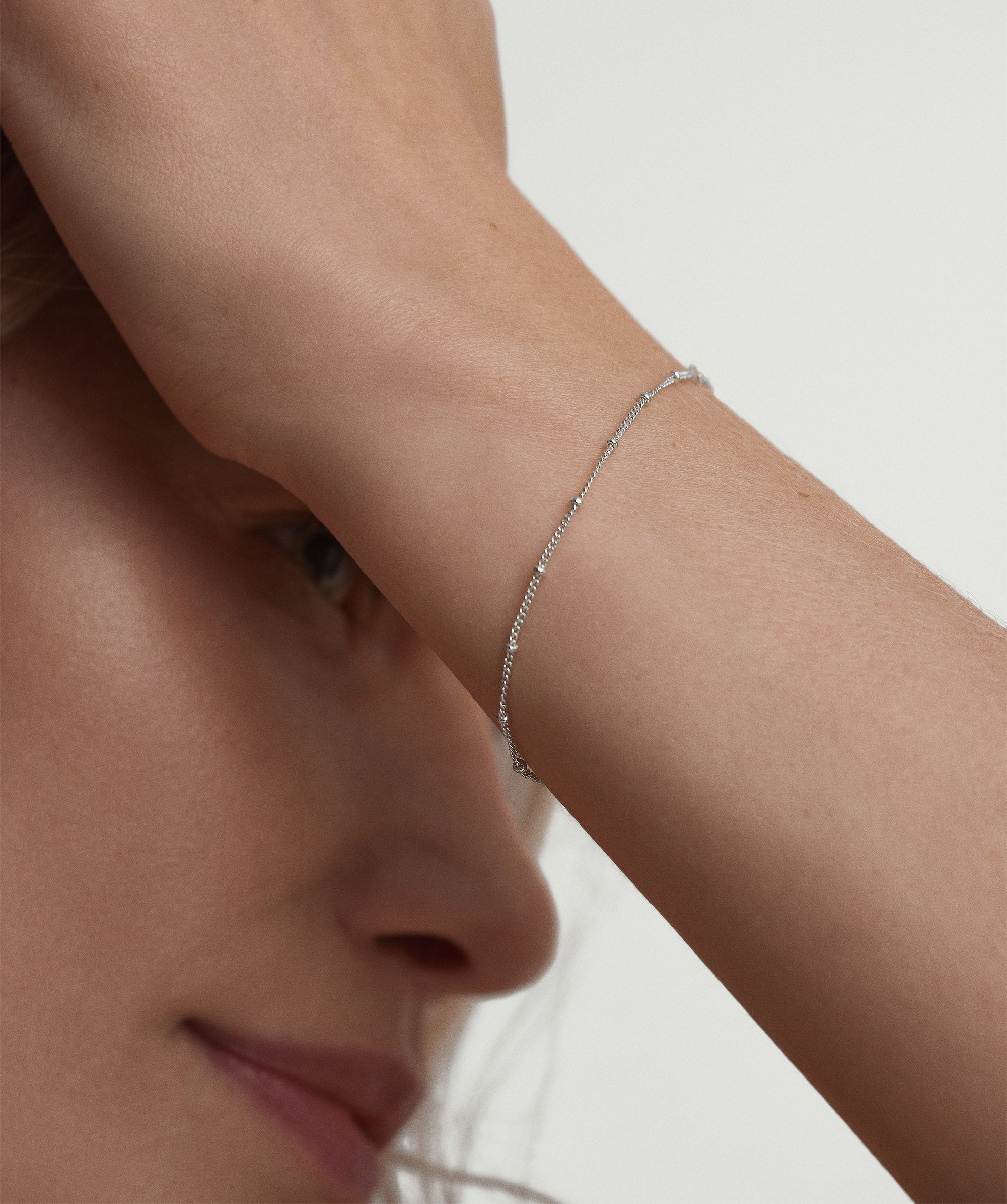 Close-up of a woman's arm wearing the Spheres Chain Bracelet, a minimal yet statement silver piece, perfect for any occasion.