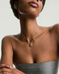 Woman wearing the Jojo Link Pendant Necklace featuring a gold pendant on a silver chain, showcasing elegant mixed metal design.