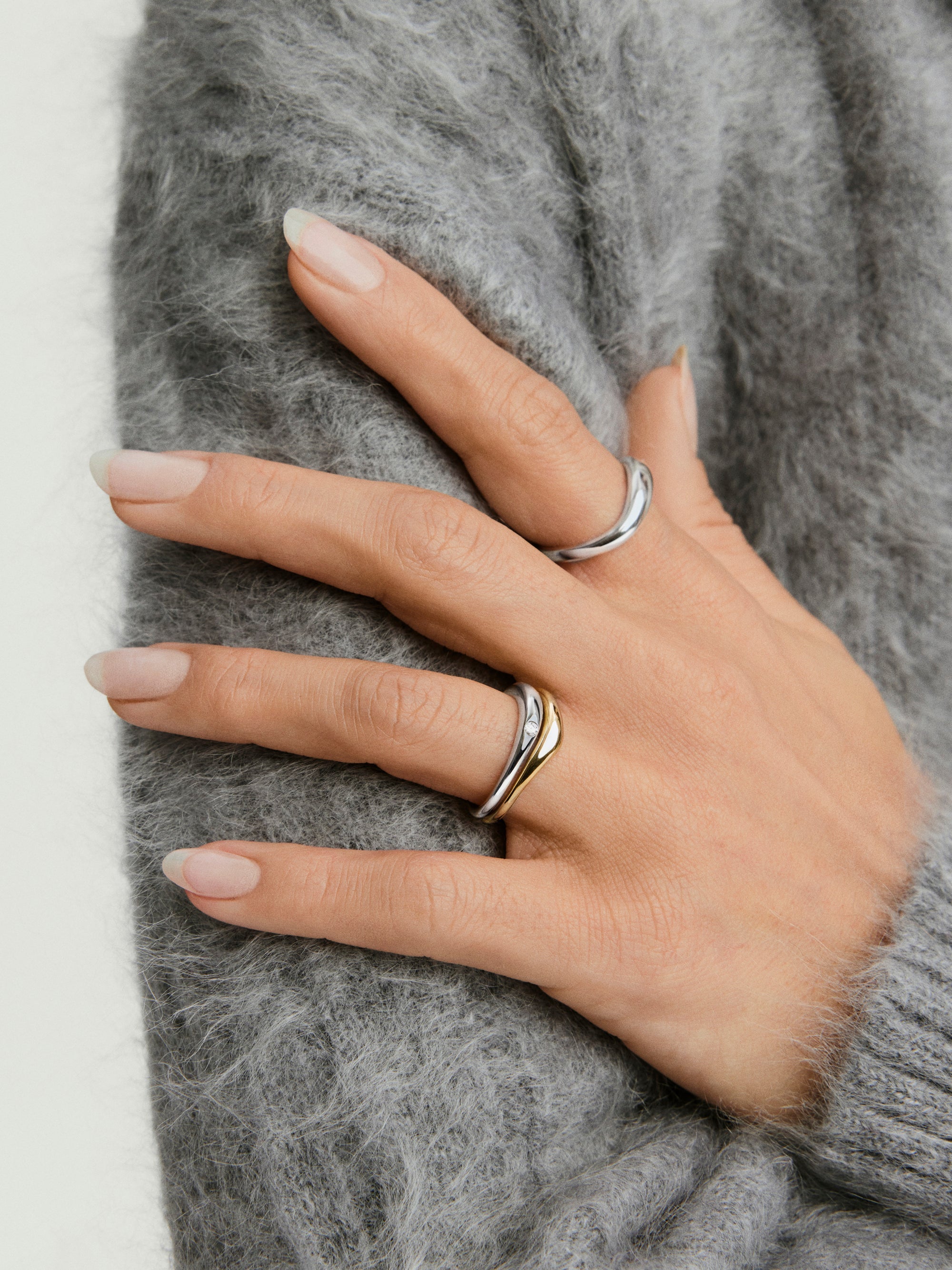 Close-up of a hand showcasing the Organic DÃ´me Nesting Ring Set, featuring two intricately designed rings that nest together as part of the DÃ´me collection.