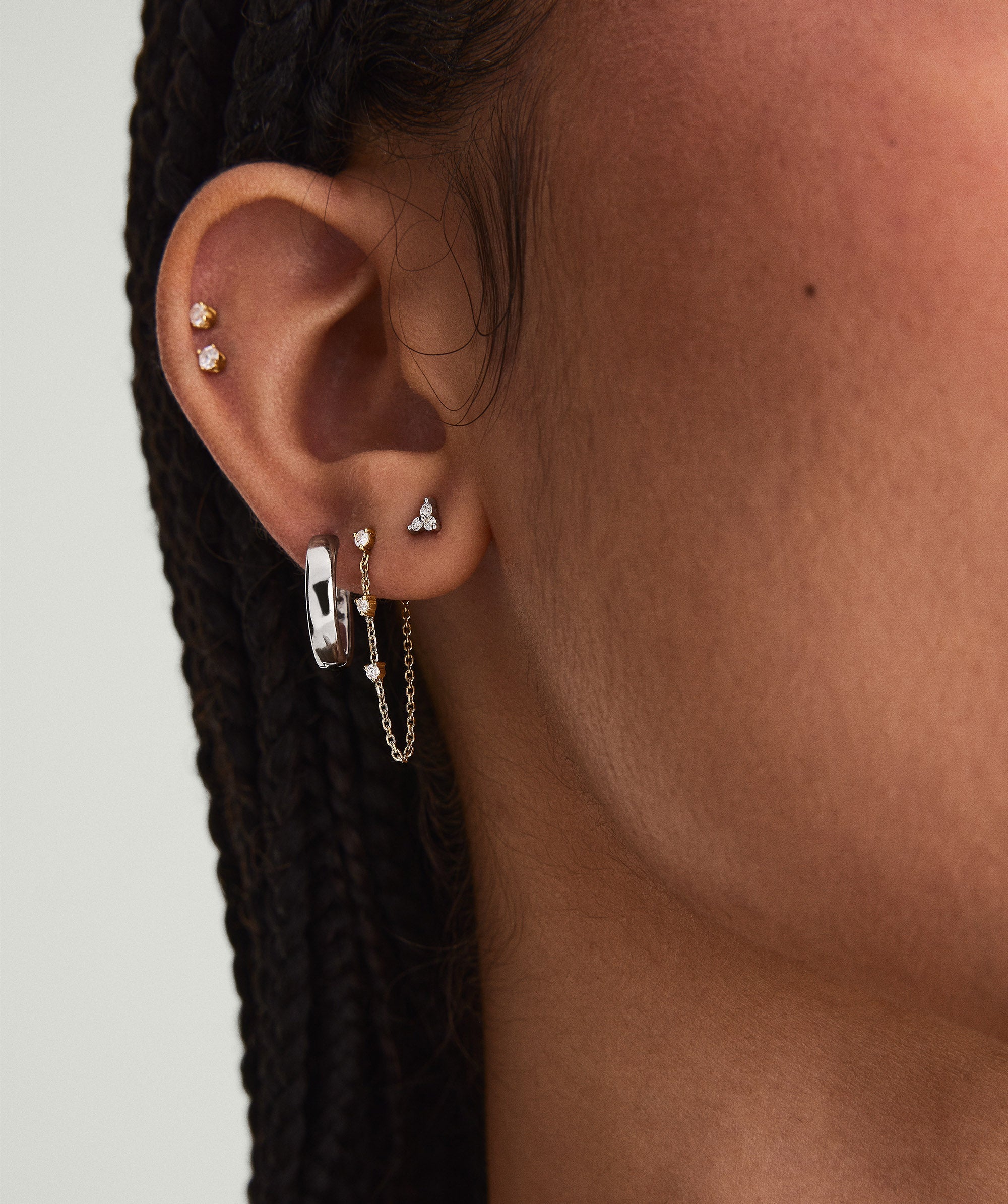 Close-up of a woman's ear wearing Mini Lotus Diamond Studs, handcrafted in 14k solid gold with responsibly sourced diamonds.