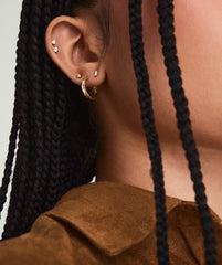 Mini Baguette Diamond Studs on a woman's ear, showcasing the handcrafted 14k solid gold setting and responsibly sourced baguette diamonds.