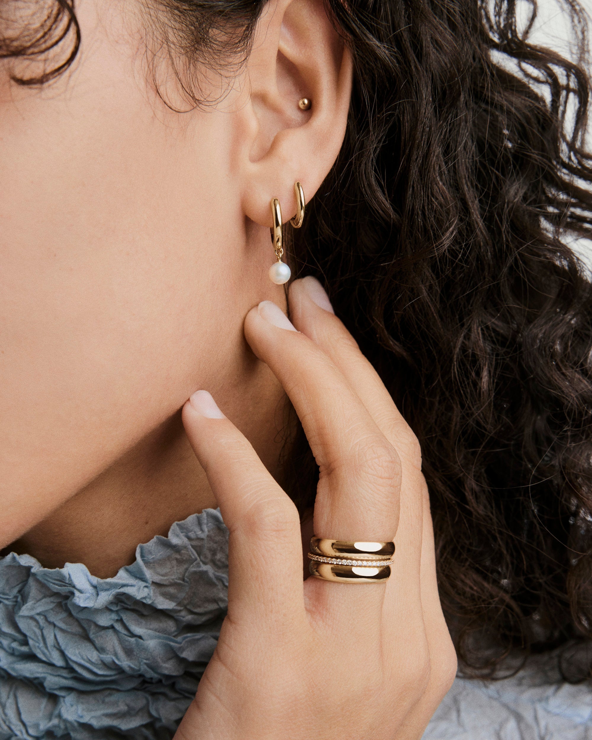 Mira Round Pearl Hoops featuring luminous mini pearls suspended from classic hoops, offering a minimal yet eye-catching design for versatile wear.