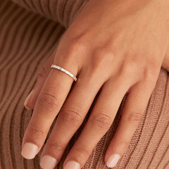 Close-up of a hand wearing the Baguette Diamond Half Eternity Band, featuring eight baguette diamonds set in a timeless band.