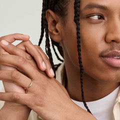 Man with braids clasping hands, showcasing the 2mm Curve Band on his finger, highlighting its lightweight and lasting design perfect for any new chapter.