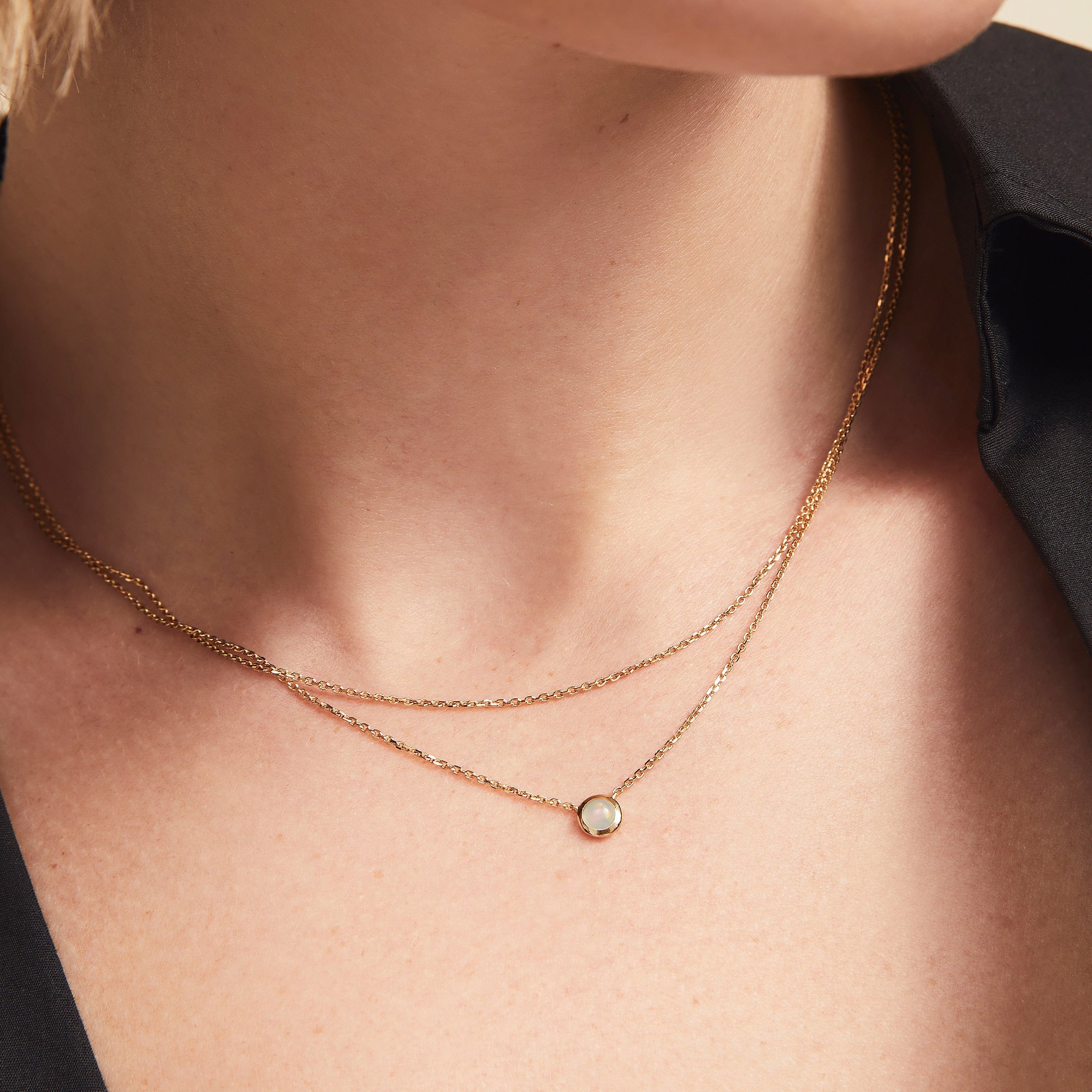 Layered Opal Necklace displayed on a person's neck, featuring two seamlessly bound chains with a natural opal pendant.