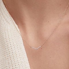 Person wearing PavÃ© Diamond Wishbone Necklace in 14k gold with 13 pavÃ© diamonds on a 15-17 inch cable chain.