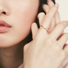 Close-up of a woman's hand wearing the PavÃ© Diamond X Ring, showcasing the intricate 14k gold band set with pavÃ© diamonds.