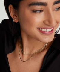 Woman smiling, showcasing the Timepiece Chain Necklace, a handcrafted 14k gold slinky chain designed for everyday wear.