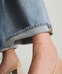 Chain Anklet: A close-up of a person's ankle adorned with a 14k solid gold chain anklet above a shoe.