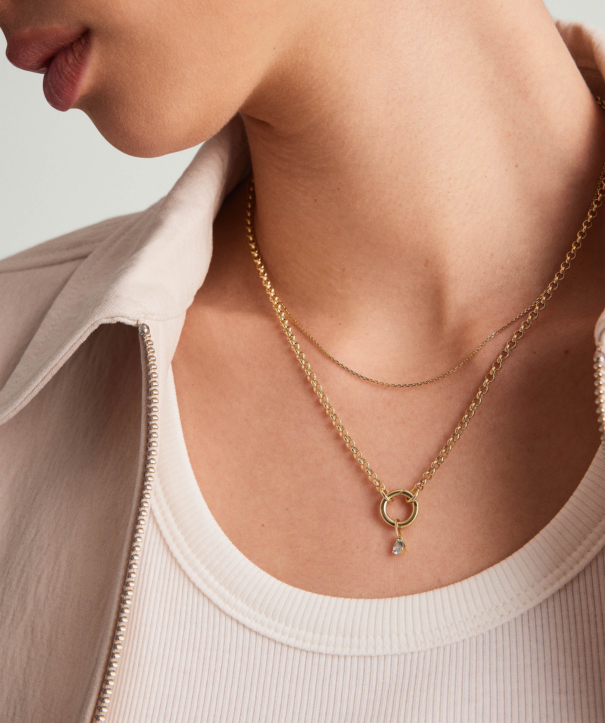 Woman wearing a 14k gold Birthstone Charm necklace, showcasing a delicate, handcrafted gemstone pendant.