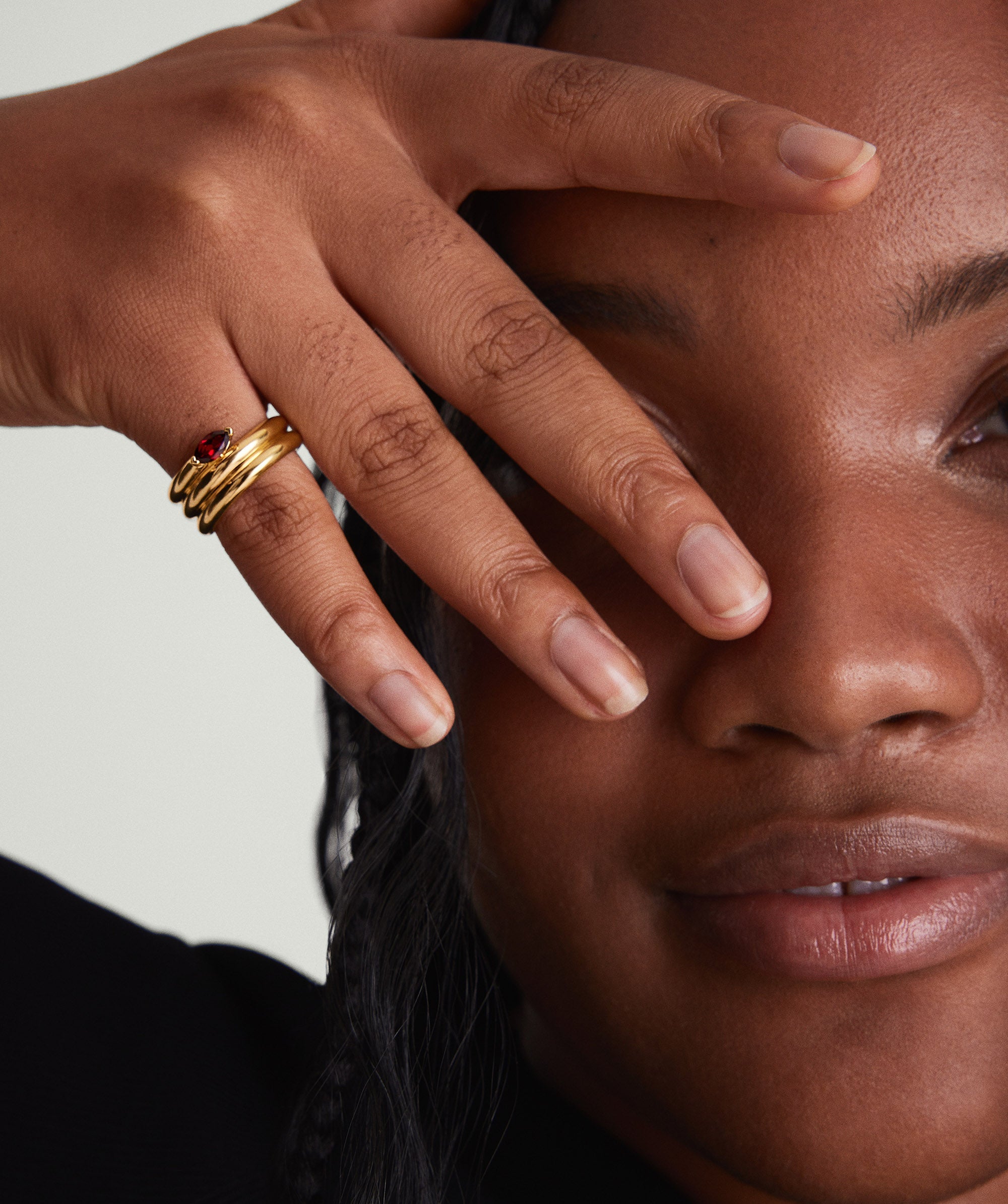 Close-up of a woman showcasing the Boa Gemstone Coil Ring on her hand, highlighting the handcrafted 18k gold vermeil jewelry piece.