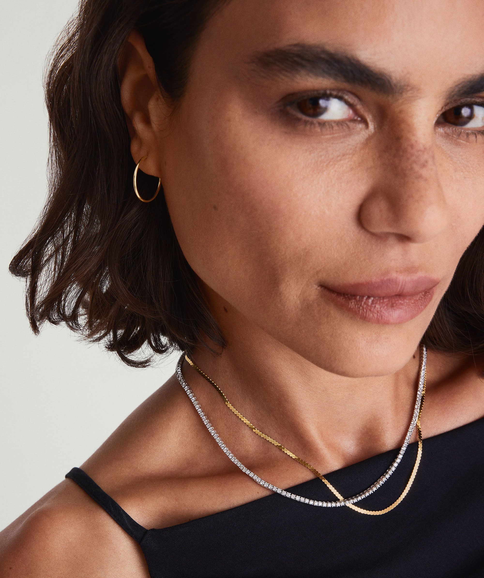Woman wearing 14k gold Diamond Tennis Necklace 1.8mm, featuring multiple sparkling diamonds, handcrafted with a secure clasp mechanism for durability and elegance.