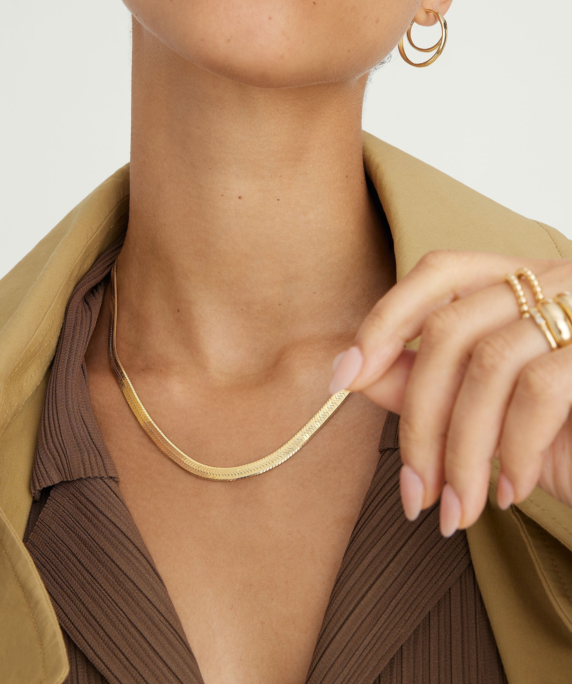 Close-up of a woman's neck wearing the Bold Herringbone Chain Necklace, showcasing its intricate design as a stylish fashion accessory.