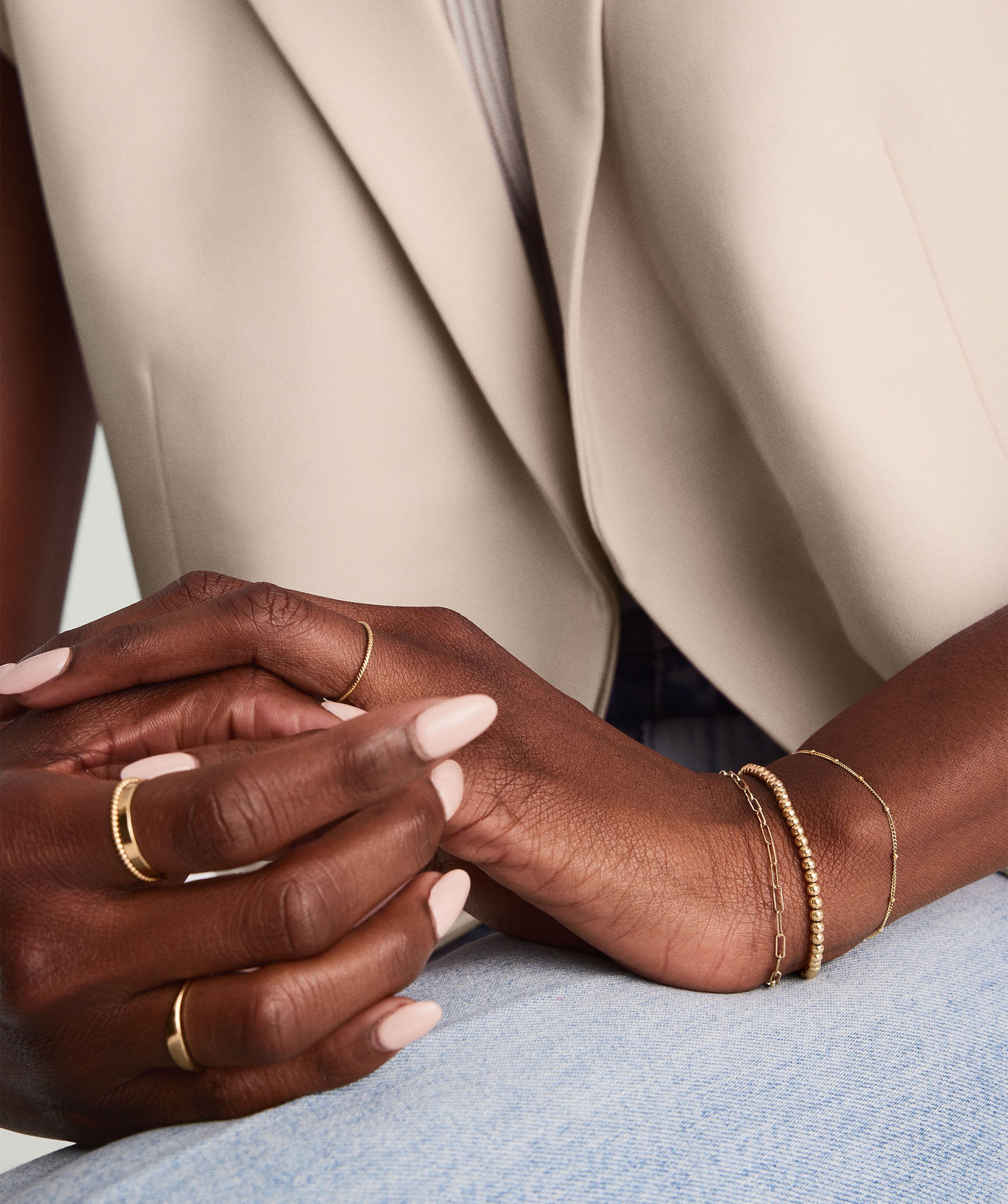 Woman's hands wearing the Bold Spheres Bracelet, a handcrafted 14k gold jewelry piece, shown in close-up for detailed view of its dainty yet bold design.