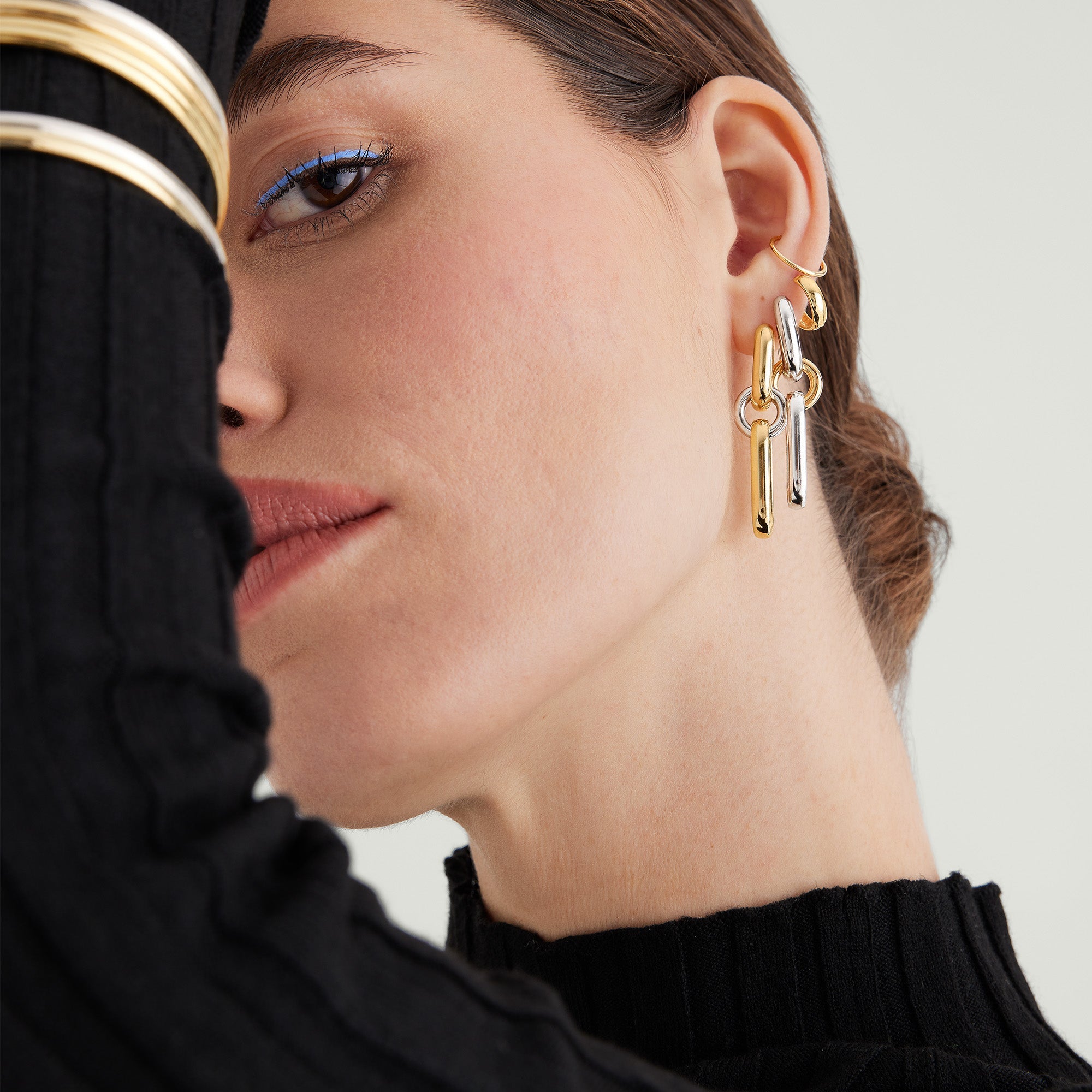 Mixed Convertible Link Earrings on a woman, styled as huggies. Handcrafted in 18k gold vermeil and sterling silver, showcasing elegant design and versatility.