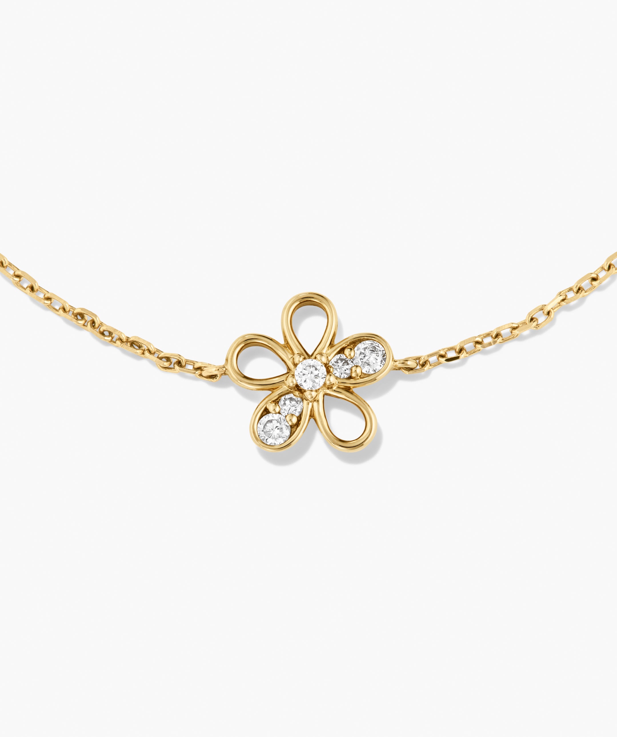 Fleurette Bracelet with a gold chain and a four-petal flower pendant, featuring pavÃ©-set diamonds on petals and center, showcasing elegant, modern design.