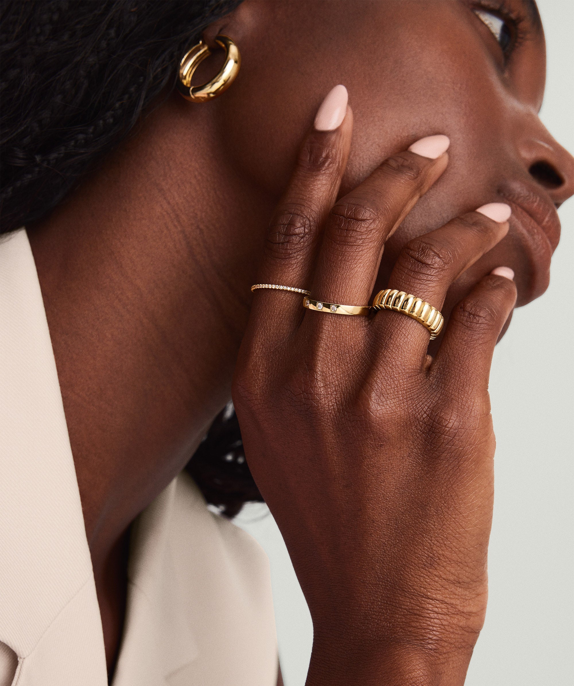 Close-up of a woman's hand wearing the Diamonds Band, a 14k gold ring adorned with diamonds, showcasing its intricate design and craftsmanship.