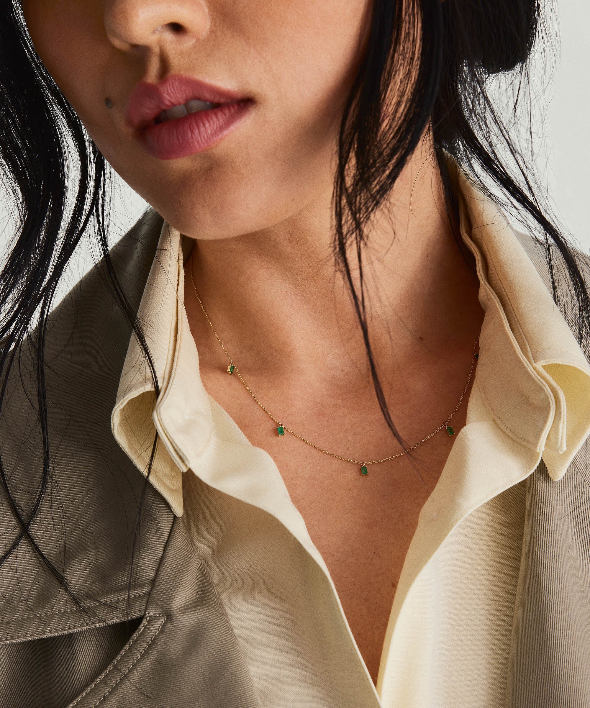 Close-up of a woman's neck adorned with the Baguette Gemstone Station Necklace, showcasing its sleek, elegant design and sparkling gemstones.