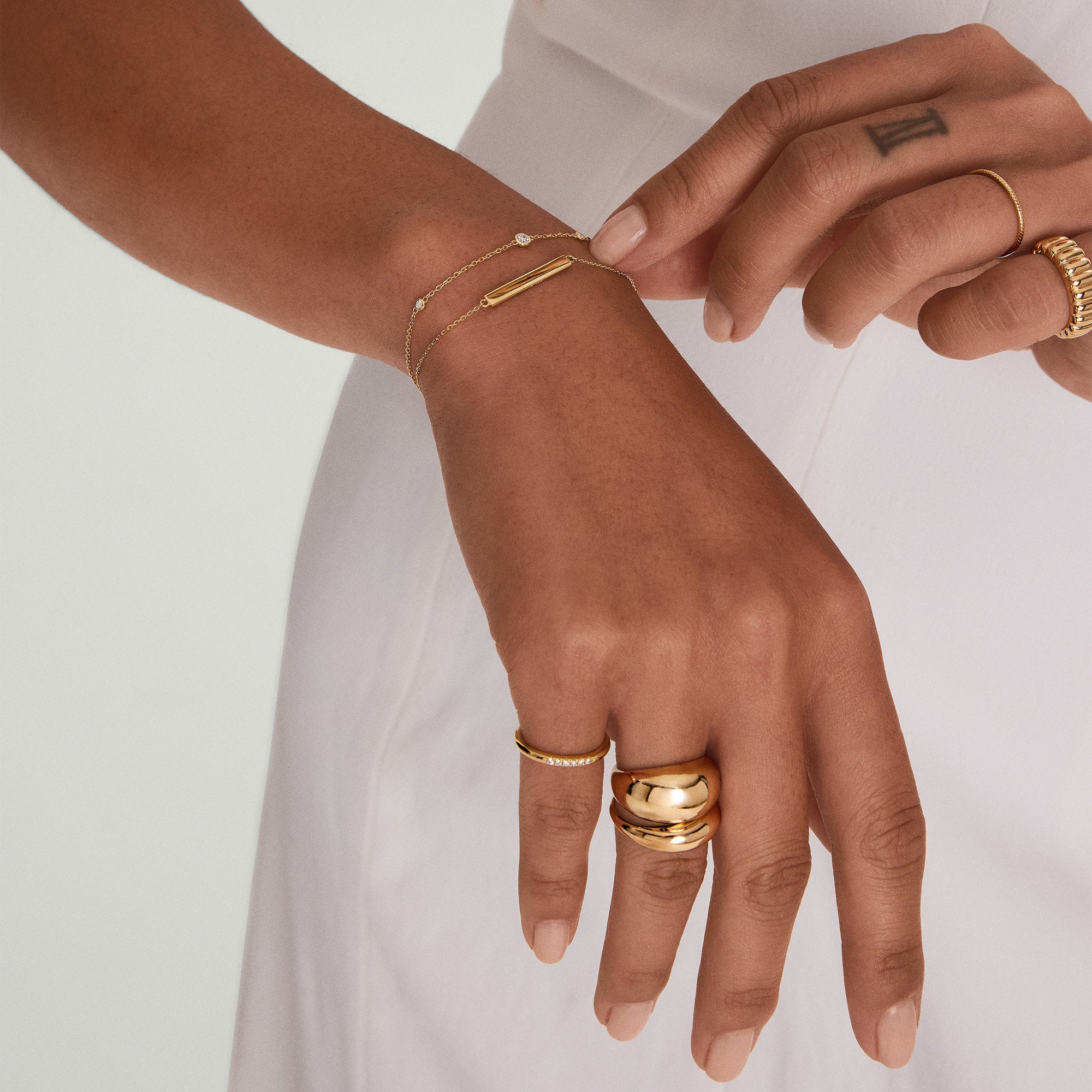 Hand wearing the Engravable Bar Bracelet in 14k solid gold, featuring a sleek, minimal design with customizable engraving on the bar.