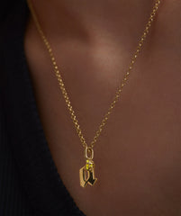 Close-up of a Baby Rolo Chain necklace, featuring a delicate gold chain with a subtle yellow gem pendant, ideal for everyday wear.