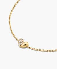 Better Half Heart Bracelet: a fine gold chain featuring a heart-shaped bead, half polished gold, half adorned with pavÃ© diamonds, symbolizing unity and elegance.